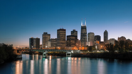 Obraz premium stunning night scene featuring city skyline with illuminated buildings reflecting on water. serene atmosphere captures beauty of urban life at dusk