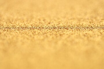 Beautiful golden glitter sparks texture as background with shallow depth of field