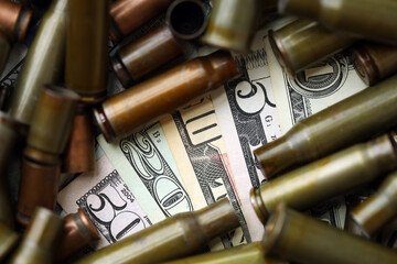 Many US dollar bills details seen through big amount of used cartridges