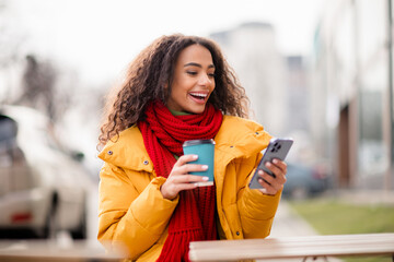 Photo of adorable cute excited positive girl wear windbreaker cafe terrace drink hot beverage cold...