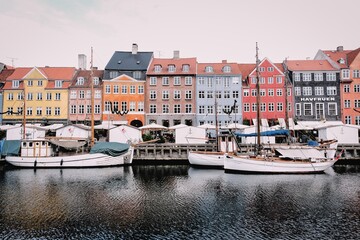 Copenhagen in Denmark, image of its traditional architecture and its traditional boats on a canal.