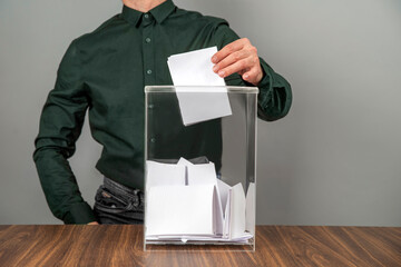 A voter casting a ballot into a ballot box on election day. Referendum, democracy,  plebiscite concept