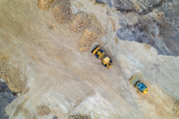 Aerial top view of earthmoving machinery working on a construction site