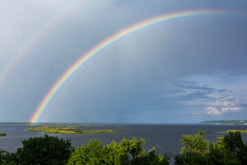 Naklejka premium double rainbow over the river