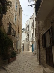 Fototapeta premium Charming narrow street in a historic European town with stone buildings and balconies