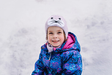 Happy and cheerful child outdoors in winter on the background of snow. Hello winter