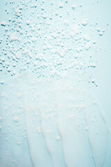 Cosmetic products on a blue background. Sample of enzyme powder and clear liquid cosmetics. Texture of cosmetic skin care product. Vertical