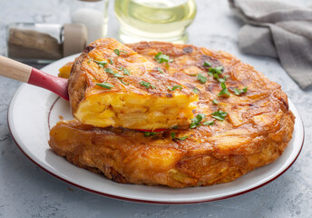 Spanish omelette with potatoes, typical spanish cuisine on gray concrete floor. Tortilla Espanola. Turkish name; Yumurtali patates