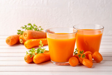 Carrot juice in a glass and fresh carrots