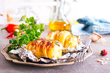 Baked loaded potato with bacon, cheese and greens