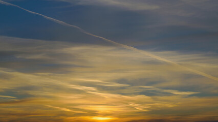 Summer evening sky in the picturesque clouds, lit by the rays of the setting sun.