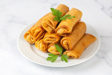 Pancakes or thin crepes stuffed with chicken and mushrooms on a plate