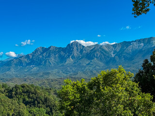 Obraz premium Scenic view of majestic Ceraunian mountain range in Albania, with clear blue sky above the peak. Slopes are covered in lush green vegetation. Hiking and outdoor activities in Albanian Alps. Wanderlust