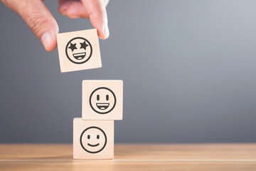 A Wooden blocks featuring smiley and sad face stickers, symbolizing the concept of choosing between happiness and sadness. The image reflects the emotional decisions we face in life