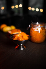 Pumpkin jam in a jar. Pumpkin jam spread on bread. The cook prepares pumpkin jam. Pumpkin jam on a black background