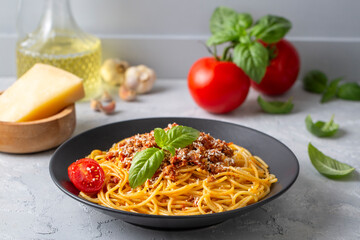 Pasta spaghetti bolognese with minced beef sauce, tomatoes, parmesan cheese and fresh basil in a plate