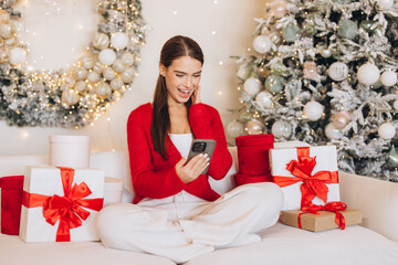 Joyful Woman Using Smartphone During Festive Christmas Celebration