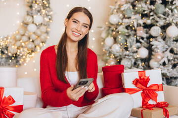 Woman Enjoying Christmas Surrounded By Gifts And Decorations