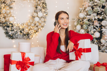 Young Woman Enjoying Christmas Call Surrounded by Gifts and Decorations