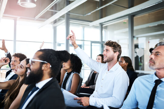 Hand raised, conference and business people in office for meeting, seminar or discussion. Question, event and team of financial advisors in audience at finance training for investment planning.