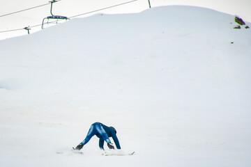 Beginner amateur skier learn to ski fall looking funny on snowy slope in ski resort. Wear jeans...