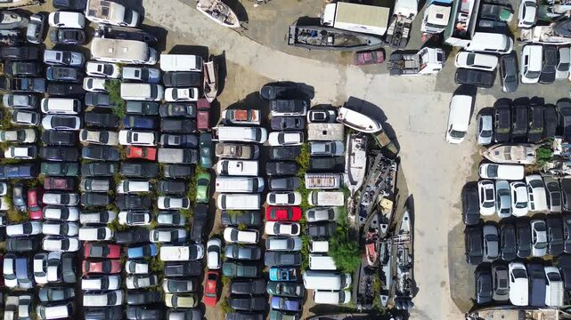 Aerial view of the large junk yard with various cars, trucks, vans and boats. Located in southern Spain, Malaga province, Cartama.