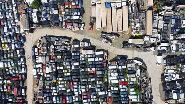 Aerial view of the large junk yard with various cars, trucks, vans and boats. Located in southern Spain, Malaga province, Cartama.