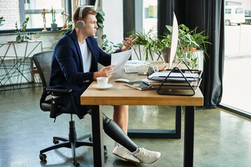 A professional man with a prosthetic leg actively participates in a business meeting from his...