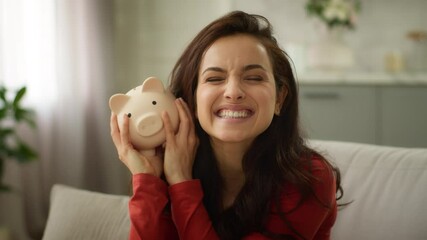 Happy excited laughing Caucasian rich business woman female girl delighted businesswoman shaking piggy bank full of money saving finance wealth cash successful investment deposit currency inside home - Powered by Adobe