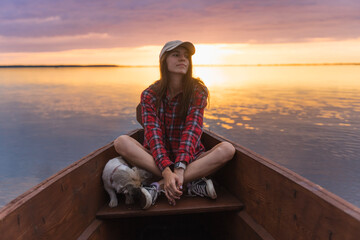 Fototapeta premium lonely women sitting on a boat on a beautiful sunset day