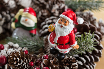 A small figurine of Santa Claus in a red and white suit holding a green sack,
