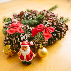 Christmas wreath including a small Santa Claus figurine and a golden bauble.