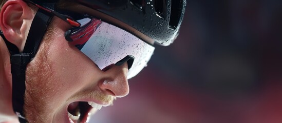 Fototapeta premium Close-up shot of cyclist mid-race, showing his intense facial expression while shouting in determination.