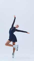 Female figure skater in motion on ice, making graceful performance isolated on white background....