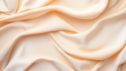 Obraz premium A soft, silky fabric in a creamy peach hue, elegantly draped to showcase its smooth texture and delicate sheen.