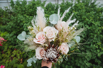 A person is joyfully holding a stunning bouquet filled with vibrant and colorful flowers right in...