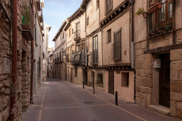 Obraz premium Narrow cobblestone street lined with historic houses in a quiet Spanish village