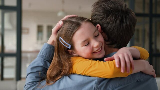 Smiling Caucasian family caring father male parent hugging embracing little girl kid happiness at home. Cheerful daughter child cuddling kiss cheek dad man love childcare tenderness custody parenthood