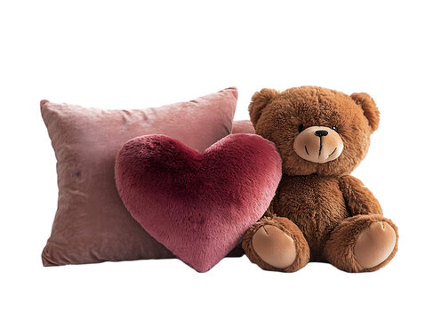 Plush teddy bear sitting beside heart-shaped and square pillows, creating a cozy and warm atmosphere.
