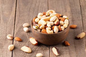 Healthy mix nuts on wooden background. Almonds, hazelnuts, cashews, peanuts, pistachios, Brazil nuts