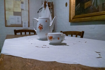 A table with a white tablecloth and two cups on it