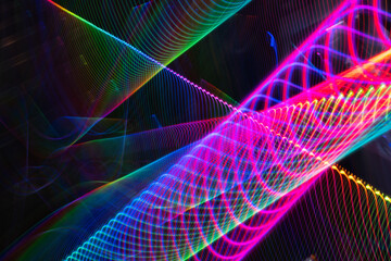 A colorful, abstract image with a rainbow of colors and a black background. The image is a representation of a wave, with the colors blending together to create a sense of movement and energy