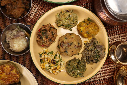 Bengali style spread verity vorta mashed bhorta potato egg brinjal shrimp prawn fish chicken liver on rustic metal tin plate