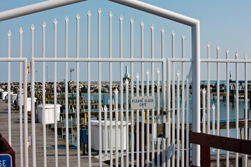 Boat piers beyond the closed gated fence within the Port Washington, Wisconsin  harbor