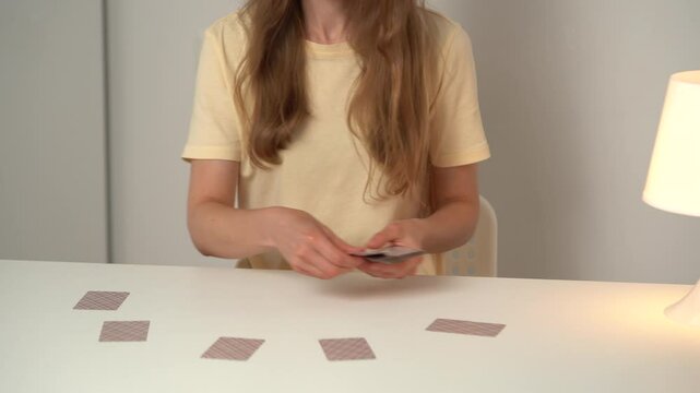 A young woman gives out classic cards to play a fool. The concept of board games and free time
