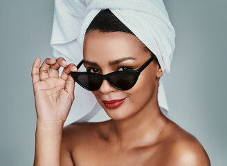 Portrait, beauty and woman with towel or sunglasses in studio on gray background for skincare...