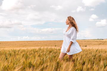 Russia, Republic of Tatarstan, Kalmash village, August 01, 2024, 17:00, girl in a dress in a wheat...