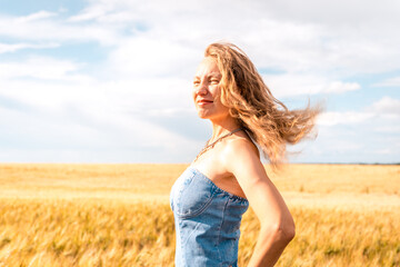 Russia, Republic of Tatarstan, Kalmash village, August 01, 2024, 17:00, girl in a dress in a wheat field in summer