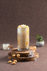 Caramel Milkshake with Whipped Cream and Caramel Drizzle: A tall glass of caramel milkshake topped with whipped cream and drizzled with caramel sauce. Served with ice cubes, milk, and caramel candies 