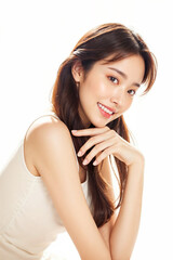 Naklejka premium A woman with long brown hair and a white tank top is smiling